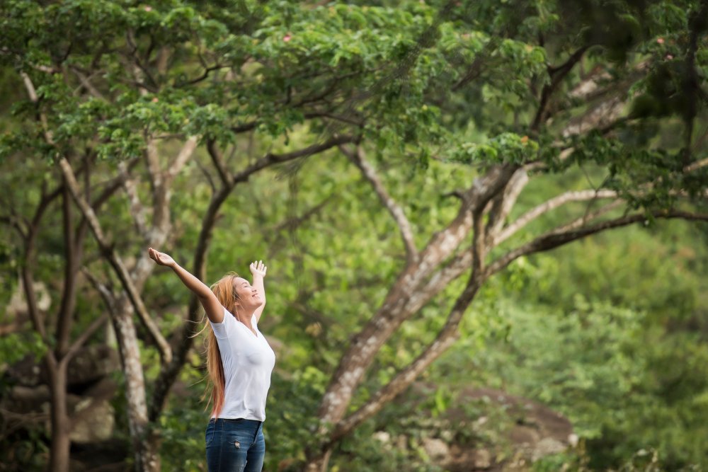 young-happy-woman-with-backpack-raising-hand-enjoy-with-nature